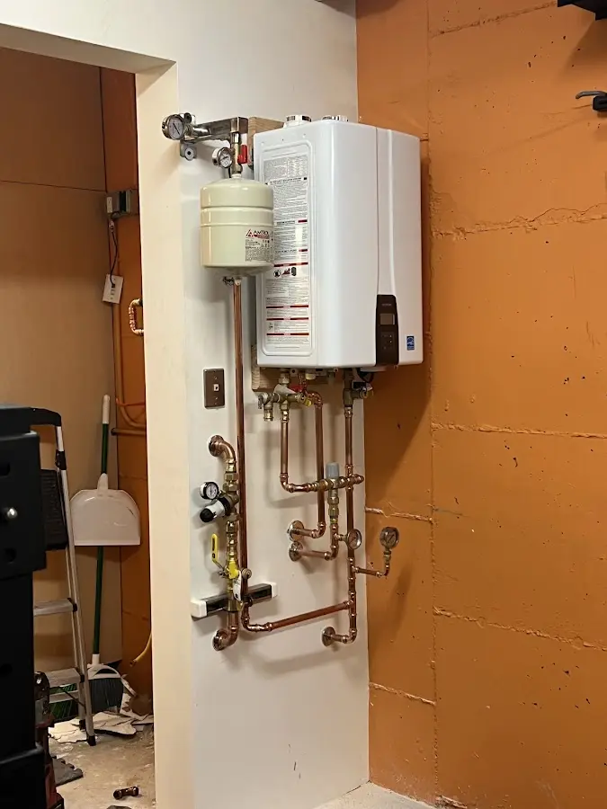 Plumbing technician inspecting water heater connections in Dodge City